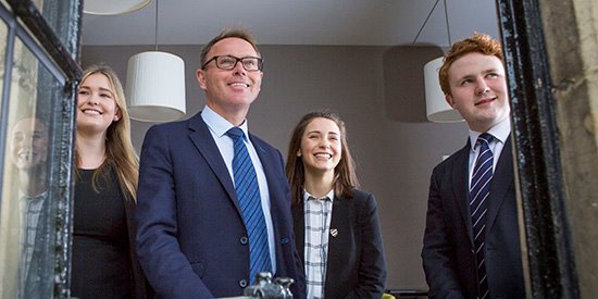 Head master smiling in window with pupils trio nav landscape.jpg